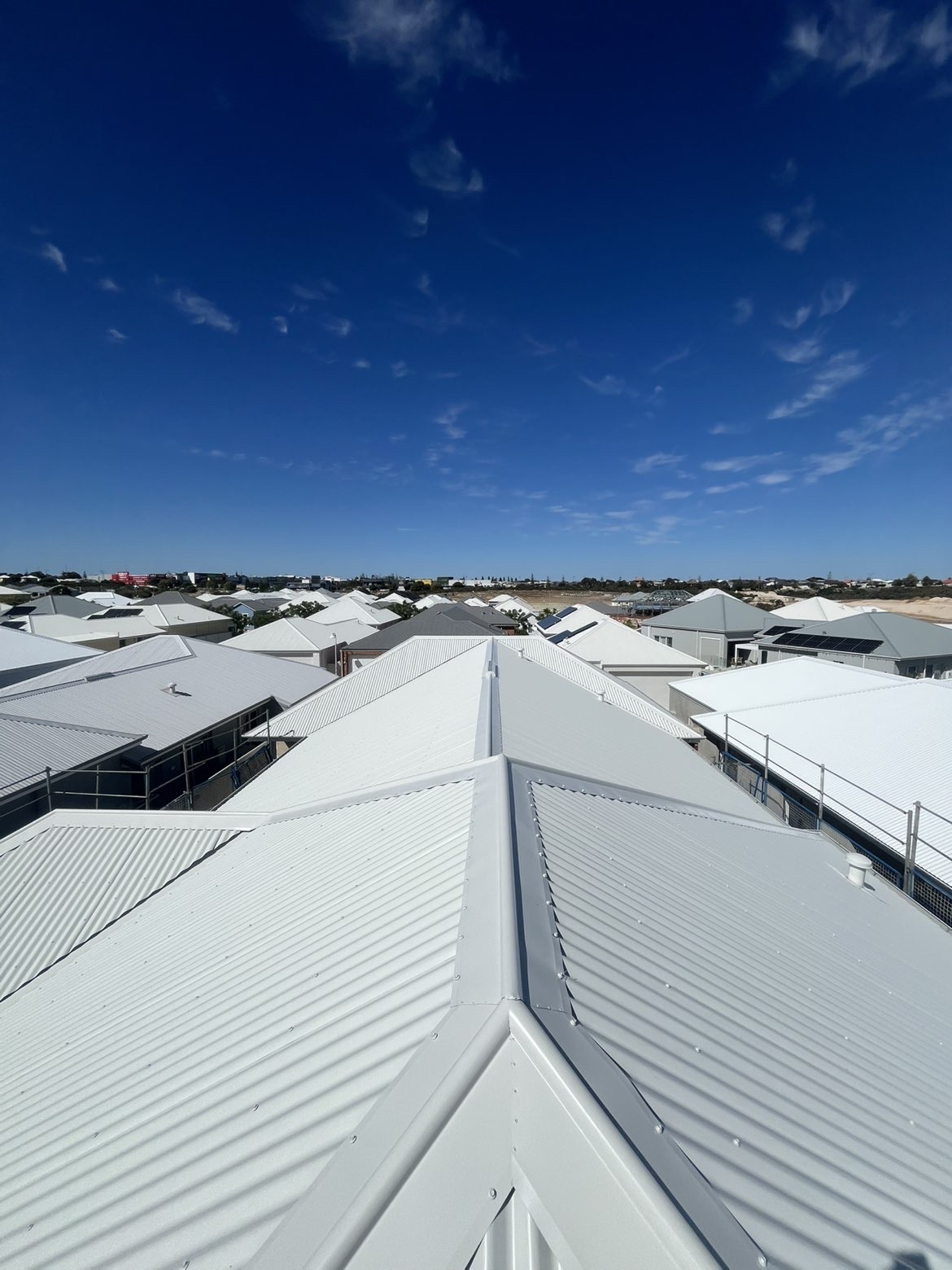 Completed Surfmist metal roof beneath a clear blue sky